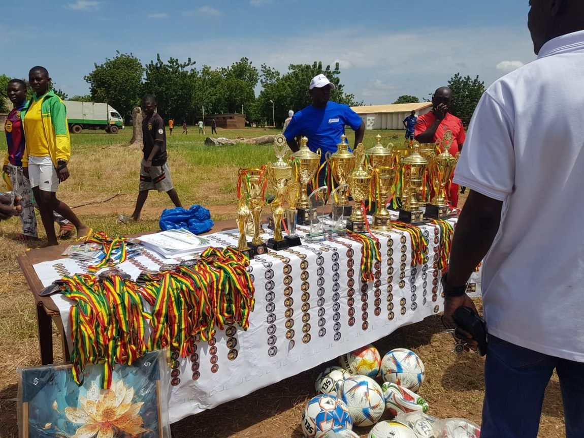 Trophies, medals, footballs, and certificates laid out for presentation